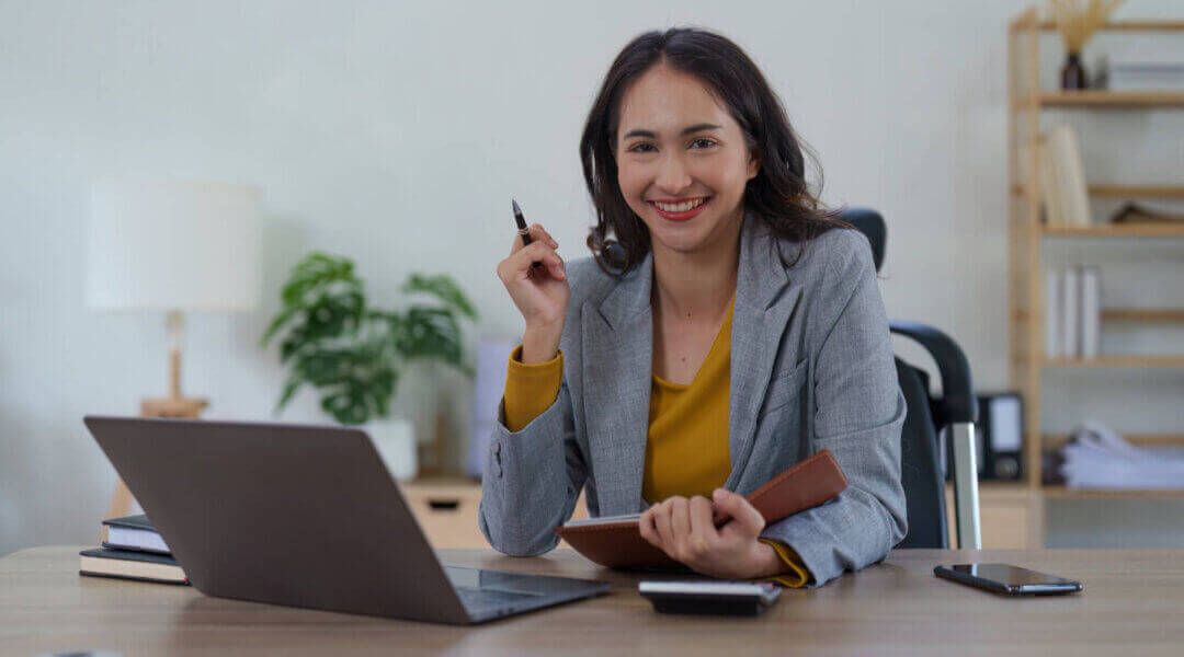 Female investment banker working at desk in her office and analyzing financial report document.