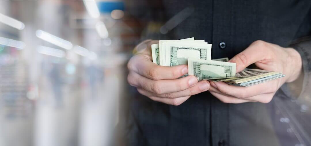 Man counting money on a blurred background of company.
