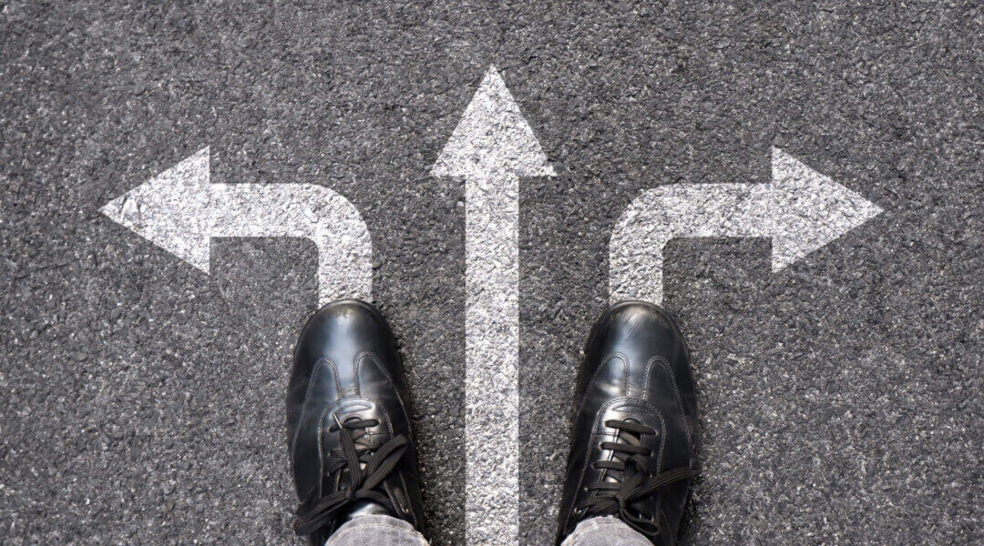 Feet and arrows on road background. Selfie feet above. Businessman standing on pathway with three direction arrows choice or move forward. Top view of business shoes walking.