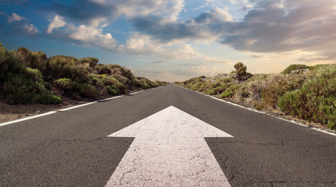 Blue sky with clouds and country road with white arrow