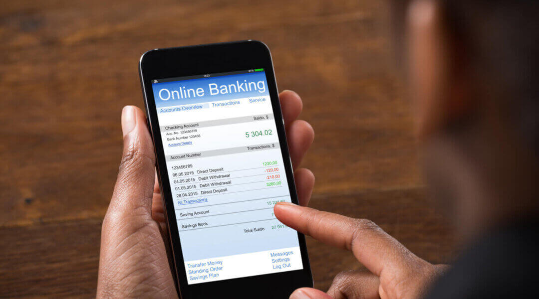 Close-up Of Young Businesswoman Using Online Banking On Mobile Phone In Office