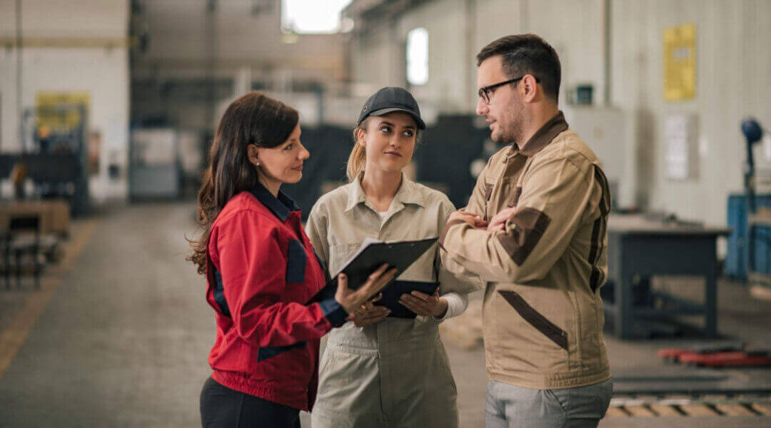 Female team leader talking to two technicians.