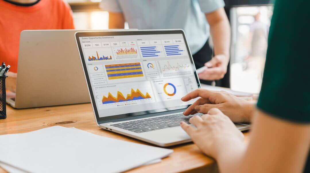 A person interacts with a digital sales dashboard displaying various performance metrics and analytics.