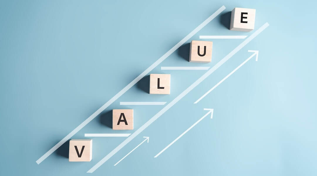 Blocks spelling out V-A-L-U-E in a Value added ladder growth concept representing development in business