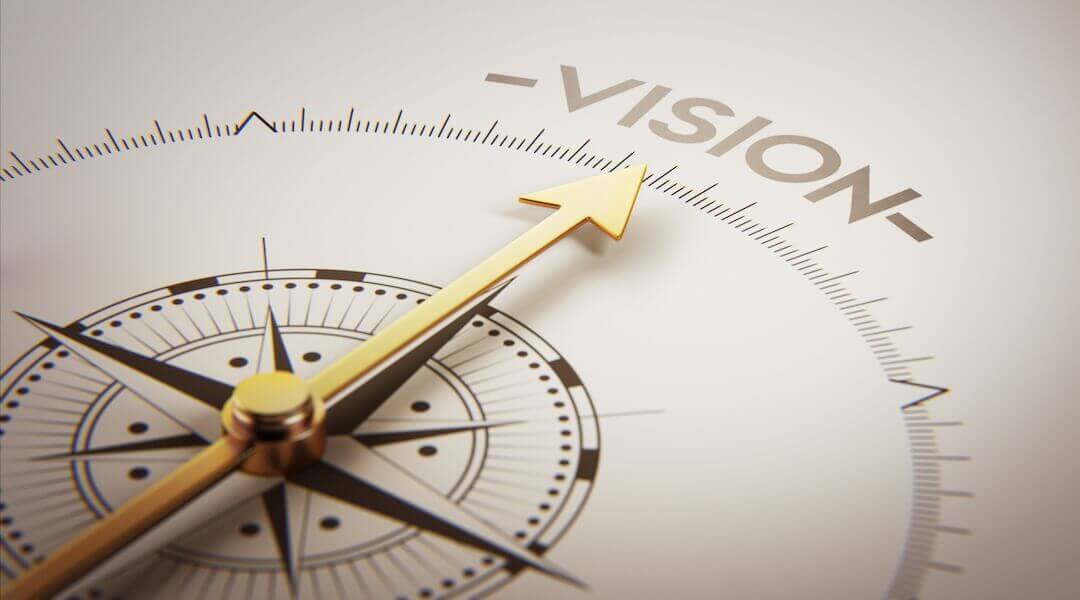 Compass with arrow pointing to the word "vision" in the north position.