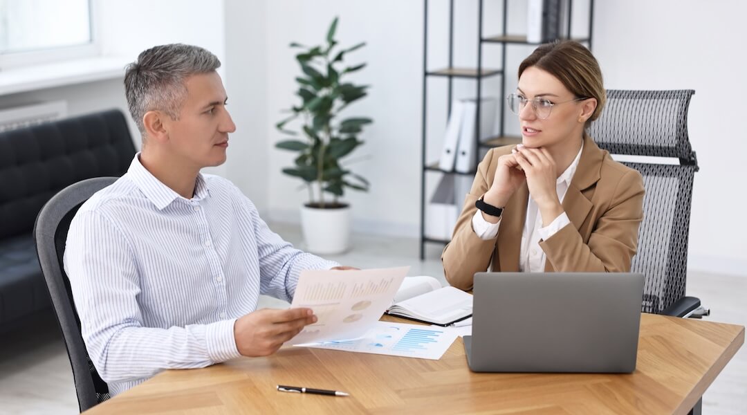CFO and Personal Wealth Advisor working at a wooden table in office