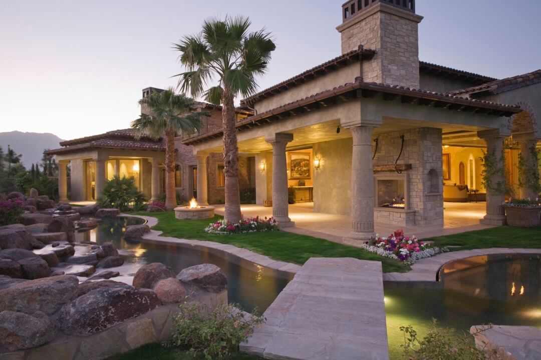 Luxury residential landscaping with custom stonework, water features, and outdoor living space at upscale home