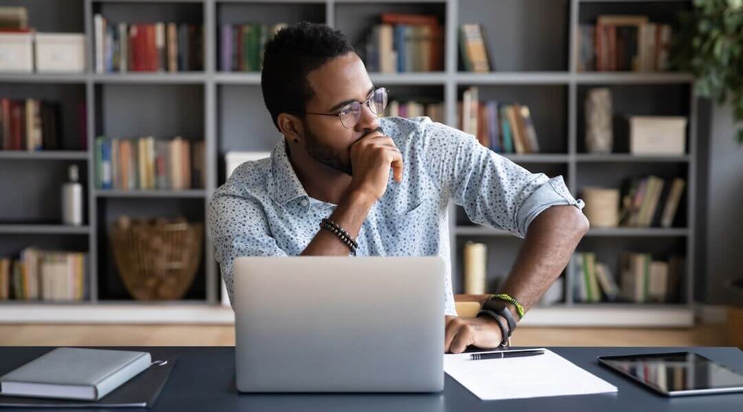 Business owner reviewing financial forecasts and trailing twelve months performance data on laptop